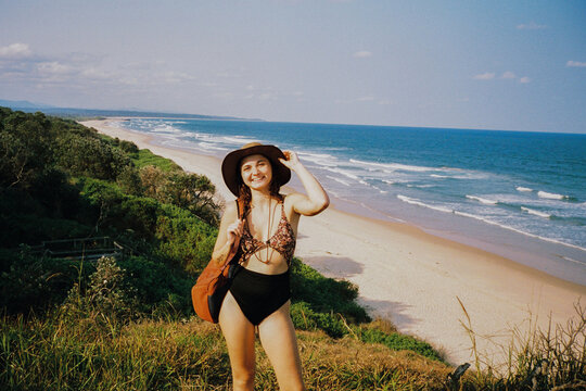 Woman smiles on the background of sandy beach 
