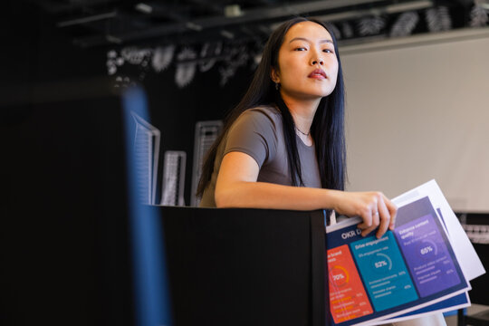 Professional woman holding business documents in office