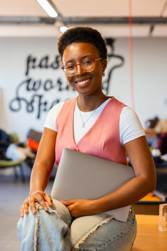 Confident professional woman holding a laptop