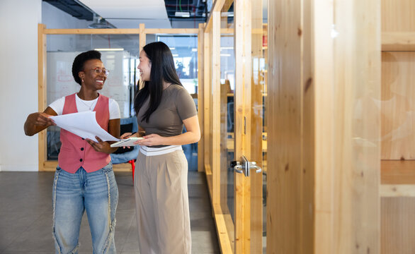 Colleagues discussing plans in modern office space