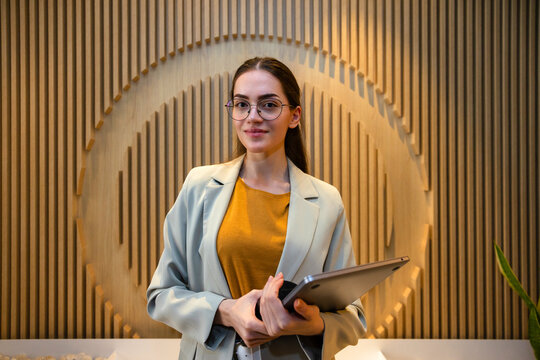 Business professional with laptop against modern backdrop