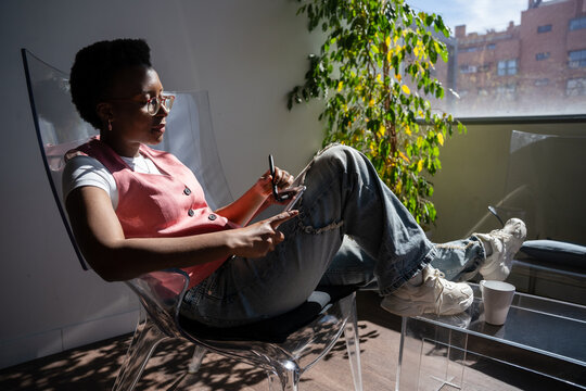 Relaxed person using phone in sunlit room