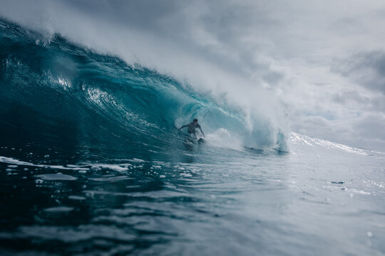 A pro surfer riding a barrel on a wave during cloudy day