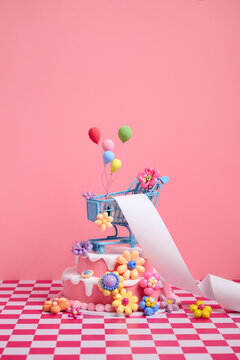 Whimsical shopping cart with balloons atop a decorated cake