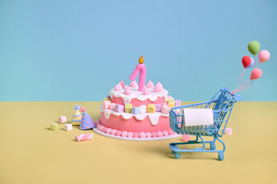 Whimsical first birthday cake with shopping cart and balloons