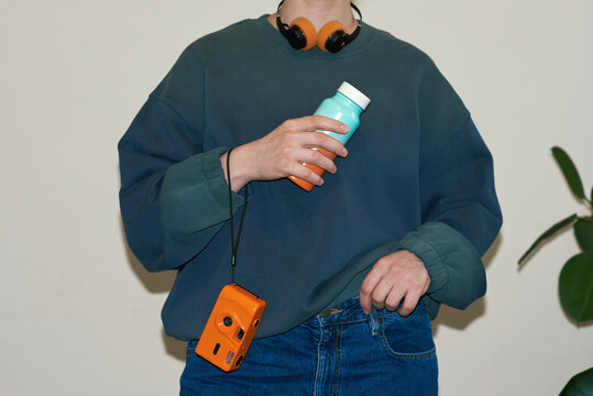 Woman holding camera and reusable bottle 