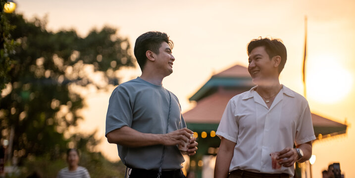Gay couple enjoying evening walk outdoors, smiling and connecting