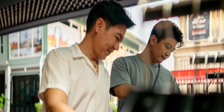 Gay asian couple enjoying retail therapy shopping together in a mall