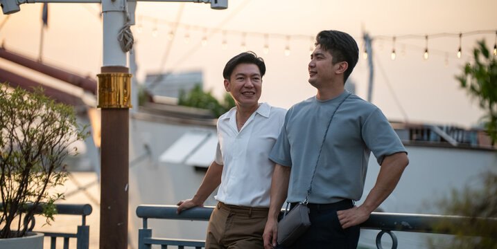 Gay couple enjoying sunset at outdoor promenade, celebrating love 