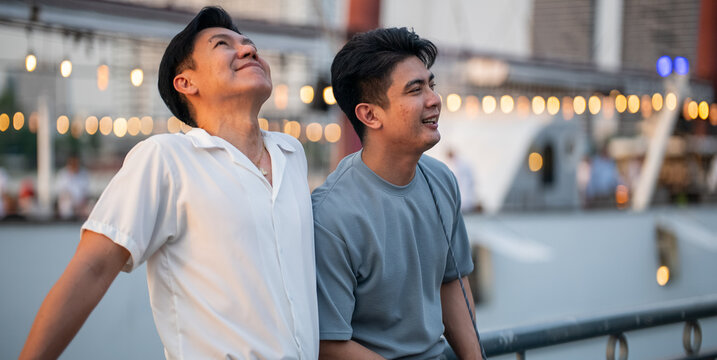 Happy gay couple enjoying city evening, smiling together outdoors