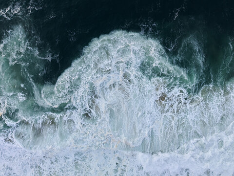 Aerial View of Ocean Waves Crashing on Shore 