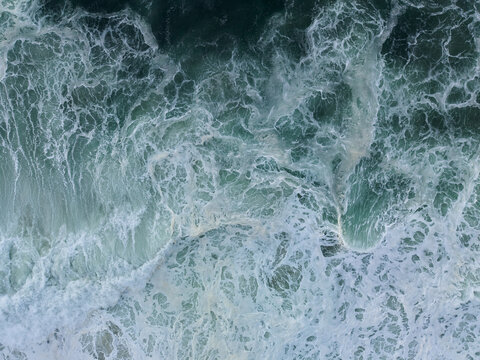 Aerial View of Ocean Waves Crashing on Shore 