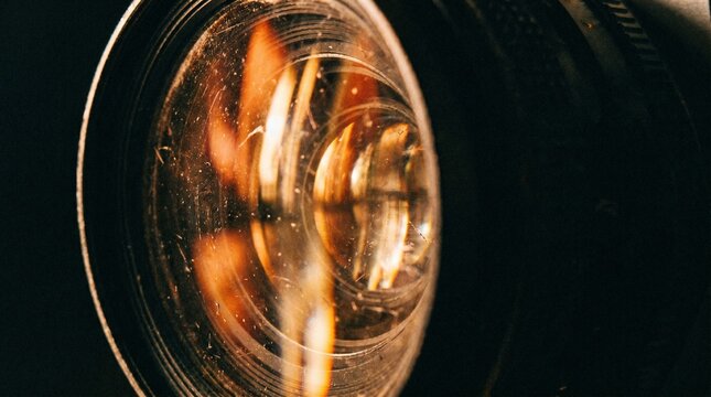 Close-up of car headlight with visible dust and scratches on dark background, detailed view.
