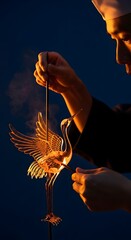 Naklejka premium Artisan Crafts Delicate Golden Crane Sculpture Under Dramatic Warm Lighting With Dark Blue Background
