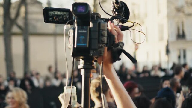 Professional cameraman filming a live public event