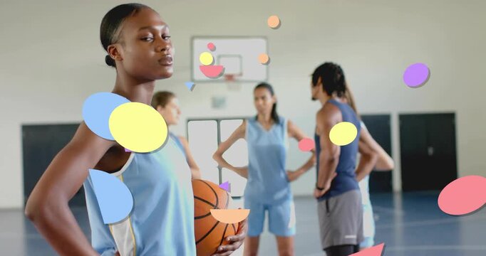 Zooming in, female player turning toward lens holding basketball, graphics growing during huddle
