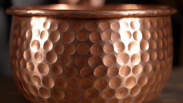 Close up of a hammered copper pot with a lid.