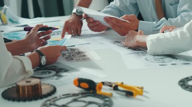 Top view of engineer pointing at turbine engine at meeting table with equipment. Aerial view of professional project manager talking and discussing about electronic generator system. Alimentation.