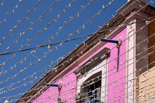 construcci&oacute;n de edificio color rosado con arquitectura colonial mexicana adornado con gu&iacute;a de luces led en el cielo