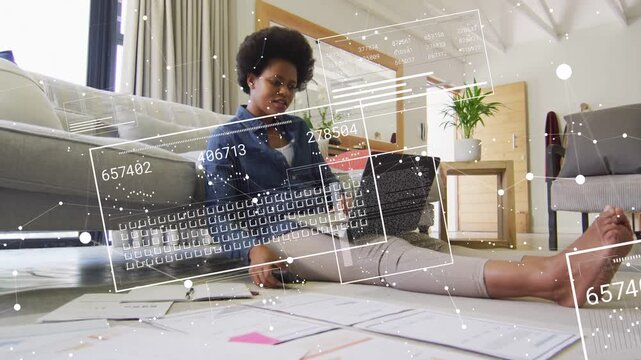 Woman doing business on floor, sorting papers, typing, lifting phone while data overlays appearing