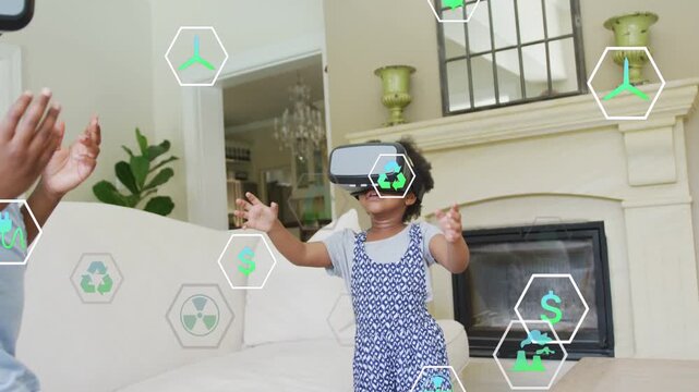 Vertical video: Two girls wearing VR headsets reaching for green hex icons, exploring technology