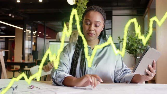 Woman reading tablet and tracing design plans, yellow graph guiding focused review