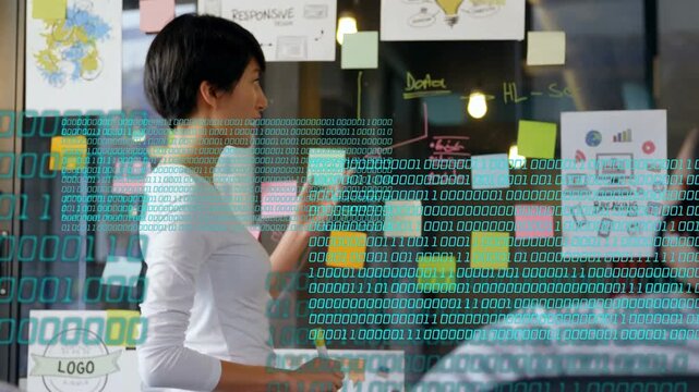 Design lead holding marker, engaging peer, turning to glass, arranging notes, binary overlay rising