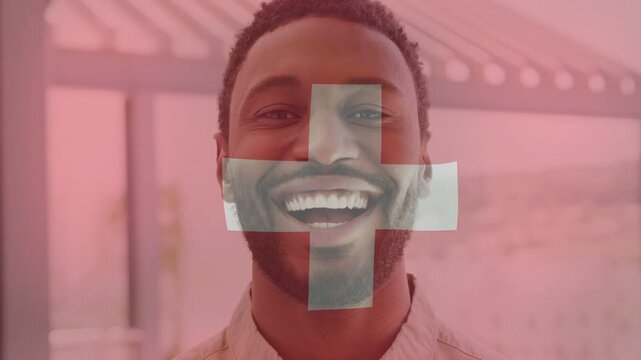 Man smiling, red overlay with white cross appearing and rotating over face for health marking
