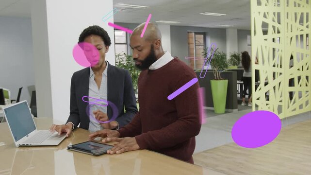 Woman pointing while man tapping tablet, magenta or purple overlaying screens while reviewing busine
