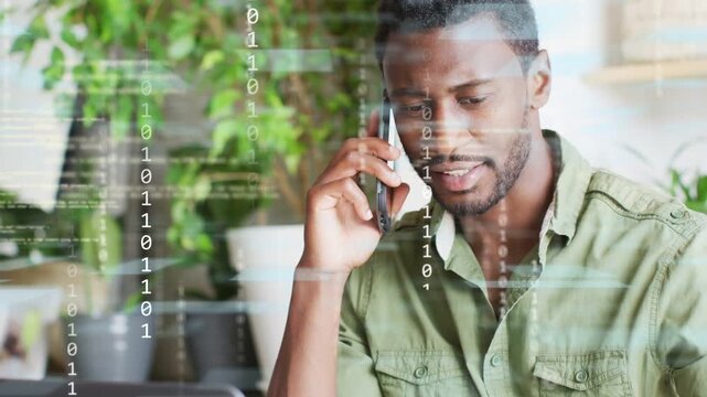 Man managing biz call, binary code overlaying after laptop input, pen noting, smiling, ending call