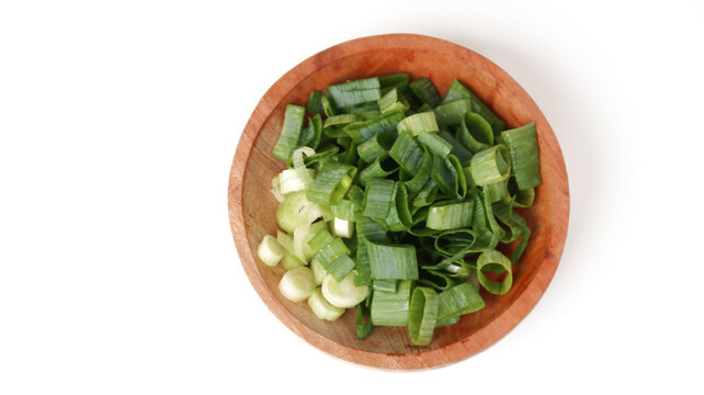top view of cut fresh leeks on wooden bowl, food ingredient	