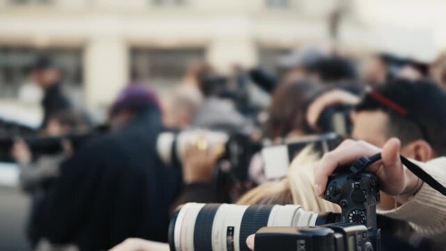 Paparazzi photographers with telephoto lenses at a public event