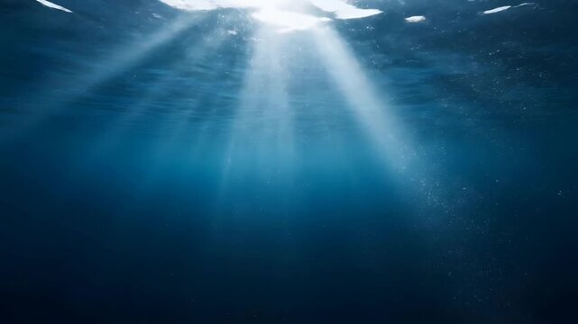 Ethereal Sunlight Rays Shimmering Through Deep Blue Ocean Water Surface From An Underwater Perspective