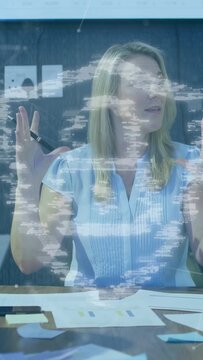 Vertical video: Mature woman raising hands leading business meeting showing charts under lock layer