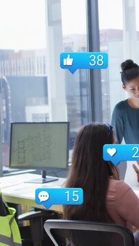 Vertical video: Seated design lead posting plan and causing social bubbles gaining feedback
