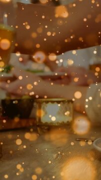 Vertical video: Adults passing plates, hands reaching sharing meal on dining table while gold bokeh