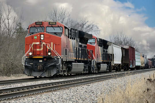 A Canadian National Railway merchandise freight train, led by two locomotives, rolls westbound through Durand, Michigan on the first full day of spring.
