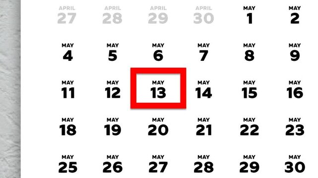 The date May 13th marked with a red cursor on the wall calendar 2026