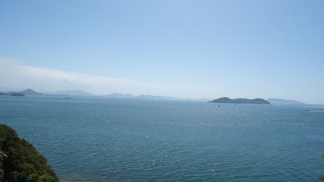 Calm sea view with distant ship and islands seen from Shimanami Kaido service area in Japan