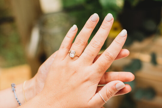 Hands holding, displaying engagement ring