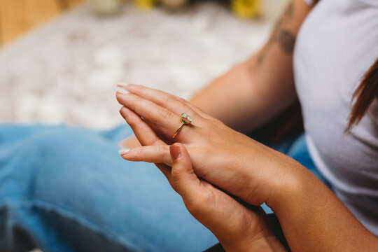 Hands holding, displaying engagement ring
