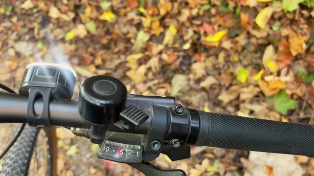 horizontal video of bicycle turning on wooded path, safety light flashing, dynamic motion in natural trail setting