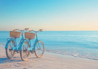Obraz premium Two light blue bicycles with wicker baskets resting on a quiet sandy beach beside a calm pastel sea at sunrise, conveying peaceful romantic seaside relaxation