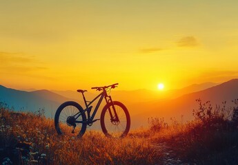 Obraz premium Mountain bike silhouetted on a grassy ridge at golden sunset with layered mountains and warm sky, evoking peaceful solitude and adventurous freedom