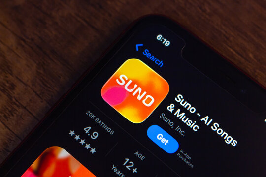 Mexico City, MEXICO - Apr 20 2026 : An iPhone on a wooden surface displaying the Suno AI Songs and Music app listing on the App Store.