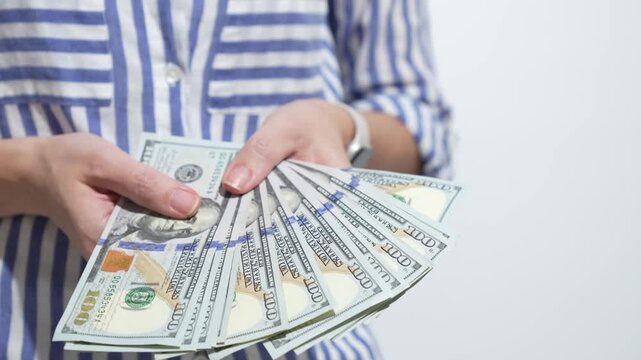 Hands holding fanned-out hundred-dollar bills, showcasing cash flow, with a gradual zoom in on the money's details and textures