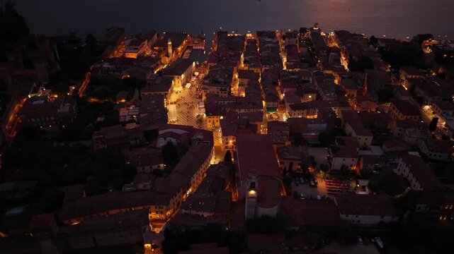 Aerial view of Lazise, Lake Garda, Italy, during sunset. Drone footage highlights the old town, medieval walls, and scenic waterfront.