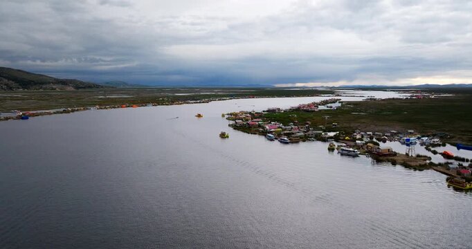 Uros floating Islands on Lake Titicana, Puno. lakeshore with boats. Drone landscape, Peru.