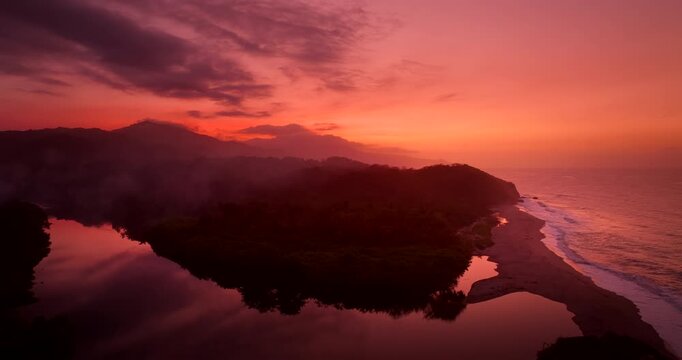 Vivid warm hues from sunset over Tayrona National Park river and coast, drone