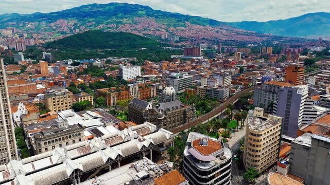 Aerial drone view of downtown Medell&iacute;n, Colombia, featuring Botero Plaza and the metro, with dense urban architecture, public space, and dynamic city life seen from above.